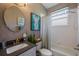 Charming bathroom with a shower over the tub, modern vanity, and decorative mirror at 8912 Heritage Bay Cir, Orlando, FL 32836
