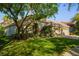 Beautifully landscaped front yard with lush green grass and mature trees shading the house at 8912 Heritage Bay Cir, Orlando, FL 32836