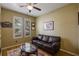 This office room features a leather couch, a modern glass table, wood floors, and natural light at 8912 Heritage Bay Cir, Orlando, FL 32836