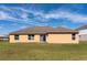 Home's rear exterior showcasing a sliding glass door to the lush backyard at 935 Gloucester Court, Kissimmee, FL 34758