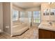 Bathroom featuring double sinks, large garden tub, and glass enclosed shower with tile flooring at 935 Gloucester Court, Kissimmee, FL 34758
