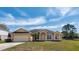 Inviting single story home featuring a manicured lawn, arched entry and two car garage at 935 Gloucester Court, Kissimmee, FL 34758