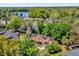 Beautiful aerial view of a single-Gathering home with solar panels, surrounded by lush trees and a lake at 10400 Hunters Trail Ct, Orlando, FL 32817