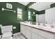 Bathroom with white cabinets, dual sinks, decorative plants, and olive green walls at 10400 Hunters Trail Ct, Orlando, FL 32817