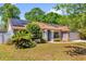 Inviting one-story home with brick accents, solar panels, lush landscaping, and a driveway at 10400 Hunters Trail Ct, Orlando, FL 32817