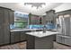 Well-lit kitchen features gray cabinets, white countertops, stainless steel appliances, and an island at 10400 Hunters Trail Ct, Orlando, FL 32817