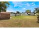 Backyard features green grass, wood fence, and storage shed at 1103 Timor Ave, Orlando, FL 32804