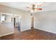 Open living room with wood-look floors, neutral walls, and a ceiling fan, leading to the kitchen at 1103 Timor Ave, Orlando, FL 32804