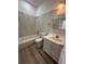 Well-lit bathroom featuring a tub with marble style tile and a modern sink at 113 Golden Crest Ct, Winter Springs, FL 32708