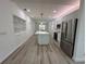 Open-concept kitchen features a large island, sleek countertops, custom backsplash, and stainless-steel appliances at 113 Golden Crest Ct, Winter Springs, FL 32708