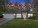 Charming single-story home featuring a two-car garage, warm stucco exterior, and well-manicured front lawn at 1234 1St Ave, Deland, FL 32724