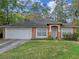 Charming single-story home with a two-car garage, well-maintained lawn, and manicured landscaping at 1234 1St Ave, Deland, FL 32724