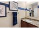 Powder room with a granite countertop and framed mirror at 1304 Independence Ln, Mount Dora, FL 32757