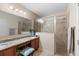 Bathroom featuring granite countertops, double sinks, and a glass-enclosed shower at 1304 Independence Ln, Mount Dora, FL 32757