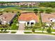 Beautiful aerial view of a house with a red tile roof overlooking a golf course and a lake in a planned community at 13349 Alderley Dr, Orlando, FL 32832