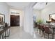 Elegant foyer with a view into the dining room, featuring a chandelier, tiled floors, and front doors at 13349 Alderley Dr, Orlando, FL 32832