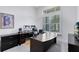 Home office has desk, black leather chair, computer, tv and bright window at 13349 Alderley Dr, Orlando, FL 32832