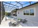 This screened pool features patio seating and outdoor loungers for entertaining and relaxation, as well as a golf course view at 13349 Alderley Dr, Orlando, FL 32832