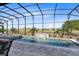 A gorgeous screened pool and spa with a rock waterfall feature overlooking the green golf course at 13349 Alderley Dr, Orlando, FL 32832