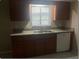 Kitchen with wood cabinets, a stainless steel sink, a view of the backyard from the window, and tiled floors at 1415 Meadowlark St, Longwood, FL 32750