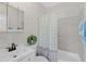 Bright bathroom with blue accents, patterned shower curtain and a vanity with a mirror at 1633 Colton, Orlando, FL 32822