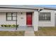 Home's front entrance features a red door, welcoming mat, and freshly planted flowers at 1633 Colton, Orlando, FL 32822