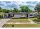 Charming single-story home featuring a well-manicured lawn, carport, and inviting red front door at 1633 Colton, Orlando, FL 32822