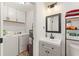 Well-lit bathroom featuring modern vanity, cabinet storage, and adjacent laundry room with washer and dryer at 1638 Mount Vernon St, Orlando, FL 32803