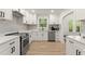 Bright kitchen featuring white cabinets, stainless steel appliances, stone countertops, and tile backsplash at 1638 Mount Vernon St, Orlando, FL 32803