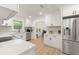Bright kitchen featuring white cabinets, stainless steel appliances, stone countertops, and tile backsplash at 1638 Mount Vernon St, Orlando, FL 32803