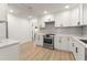 Bright kitchen featuring white cabinets, stainless steel appliances, stone countertops, and tile backsplash at 1638 Mount Vernon St, Orlando, FL 32803