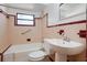 Retro pink-tiled bathroom featuring a tub with shower and matching toilet and sink at 1807 Yorkshire Dr, Winter Park, FL 32792