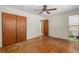 Bedroom with wood floors, ceiling fan, closet, and an adjacent bathroom at 1807 Yorkshire Dr, Winter Park, FL 32792