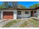 Close up of the home's front exterior with a garage and walkway to the front door at 1807 Yorkshire Dr, Winter Park, FL 32792