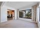 Bright living room with carpet and large window offering natural light; flows to adjoining room at 1807 Yorkshire Dr, Winter Park, FL 32792