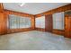 Cozy living room featuring wood-paneled walls, ample natural light, and classic terrazzo flooring at 1807 Yorkshire Dr, Winter Park, FL 32792
