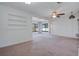 Bright living room with carpet, ceiling fan and built in shelves, adjacent to bright sunroom at 1807 Yorkshire Dr, Winter Park, FL 32792