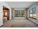 Inviting living room featuring neutral carpet, large windows with floral curtains, and access to the kitchen at 1807 Yorkshire Dr, Winter Park, FL 32792