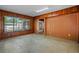 The living room with original wood paneling features a large window and access to other rooms at 1807 Yorkshire Dr, Winter Park, FL 32792