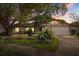 Exterior twilight view of a charming home with manicured landscaping and a two-car garage at 2508 Osage Trl, Fern Park, FL 32730