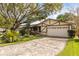 Charming home exterior featuring a well-manicured lawn, mature trees, and a two-car garage at 2508 Osage Trl, Fern Park, FL 32730