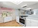 Well-lit kitchen featuring modern appliances, white cabinetry, hardwood floors, and ample natural light at 2508 Osage Trl, Fern Park, FL 32730