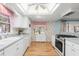 Bright kitchen with white cabinets, updated appliances, and hardwood floors at 2508 Osage Trl, Fern Park, FL 32730
