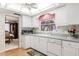 Bright kitchen with white cabinets, appliances, and a window with natural light and pink valance at 2508 Osage Trl, Fern Park, FL 32730