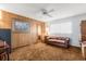 Living area features wood paneled walls, neutral carpet, ceiling fan and a cozy leather couch at 2508 Osage Trl, Fern Park, FL 32730