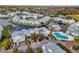 Aerial view capturing waterfront properties, lush landscaping, and a community pool at 2568 Woodgate Blvd # 204, Orlando, FL 32822