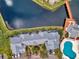 Aerial view of waterways, residential buildings with a community pool and neatly manicured green spaces at 2568 Woodgate Blvd # 204, Orlando, FL 32822