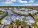 Aerial view showcasing the community with waterfront properties, a water feature, and palm trees at 2568 Woodgate Blvd # 204, Orlando, FL 32822