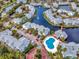 Stunning aerial view of waterfront townhomes with a large pool and lush landscaping at 2568 Woodgate Blvd # 204, Orlando, FL 32822
