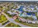 Beautiful aerial view of a community featuring waterfront property, lush landscaping, and a community pool at 2568 Woodgate Blvd # 204, Orlando, FL 32822